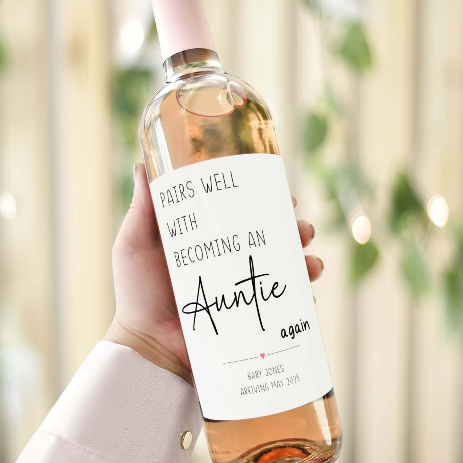 A wine bottle with a custom label reading "Pairs well with becoming an Auntie again" with a personalised pregnancy announcement message.