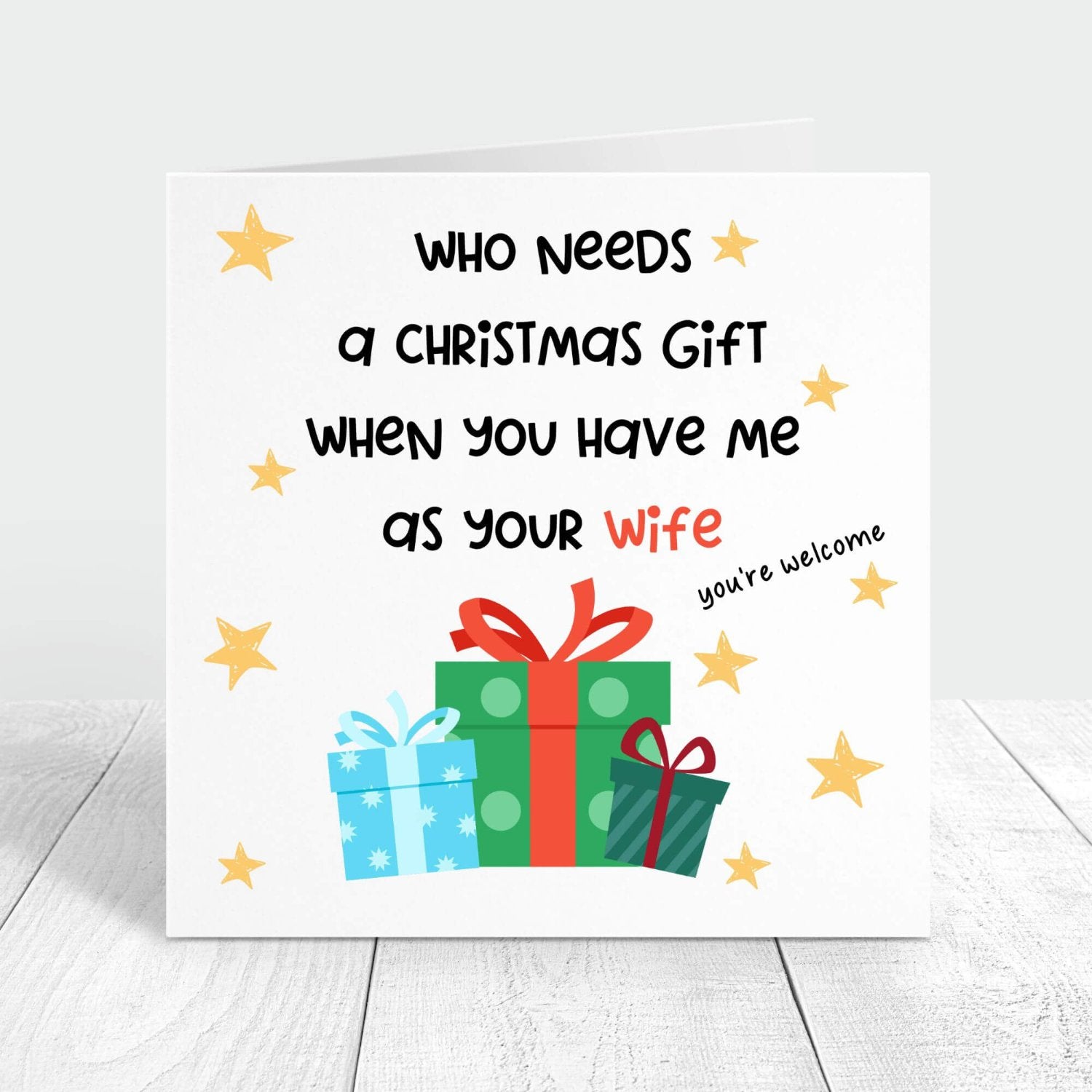 Funny Christmas card with the message "Who needs a Christmas gift when you have me as your wife?" decorated with colourful presents and stars. Perfect for sharing a laugh with your husband.