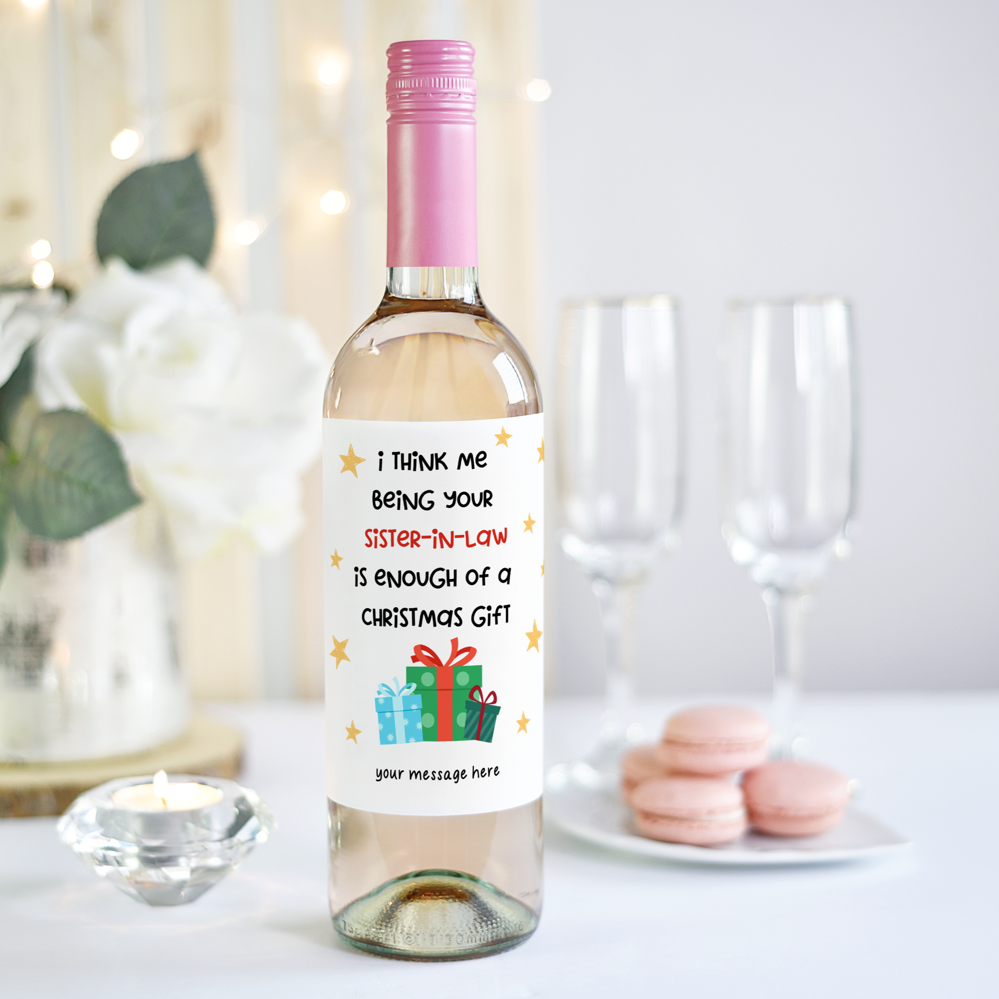 Close-up of a personalised wine bottle label reading “I think me being your sister-in-law is enough of a Christmas gift” with holiday decorations.