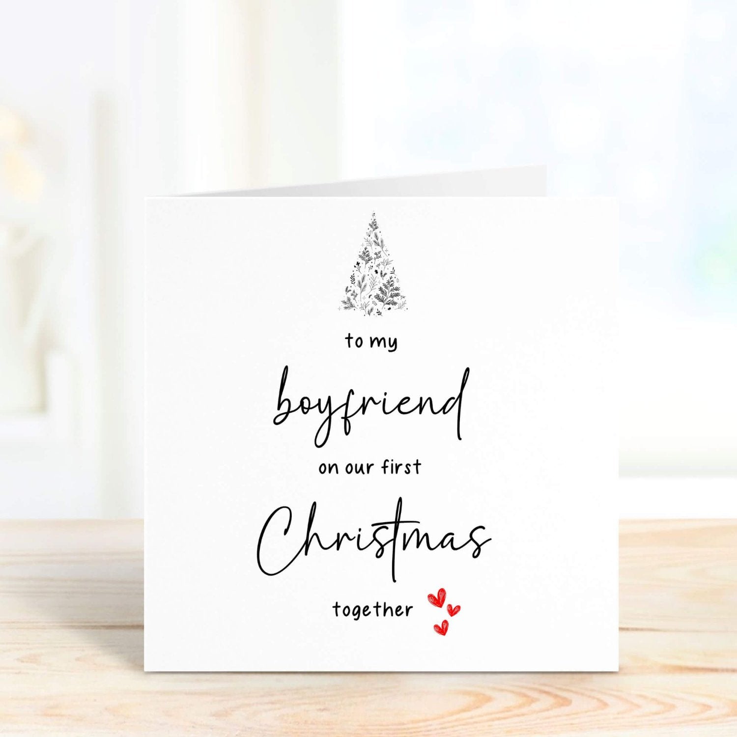 First Christmas card for boyfriend with customisable message, decorated with a Christmas tree and hearts, perfect for couples celebrating their first holiday season together.