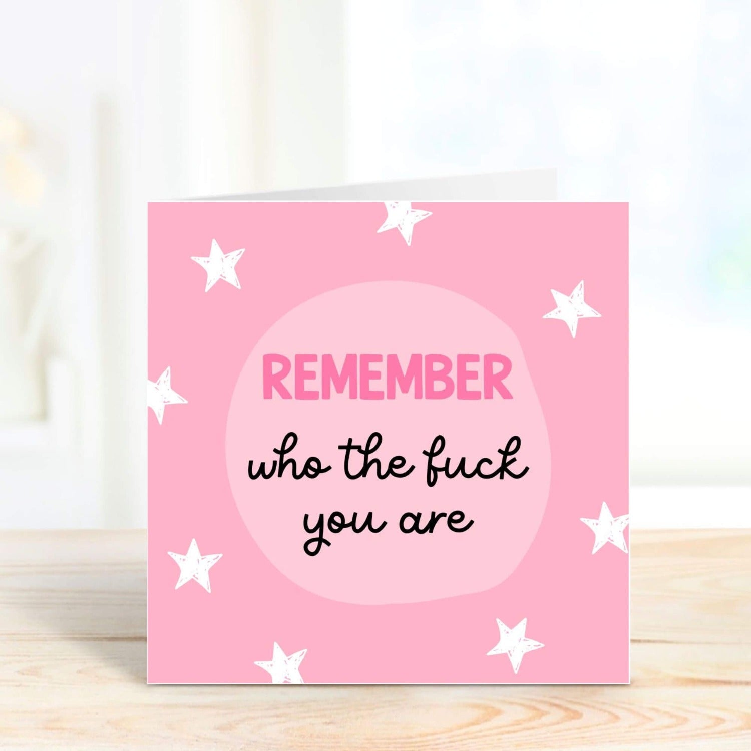 a pink card with white stars and a message 'remember who the fuck you are'