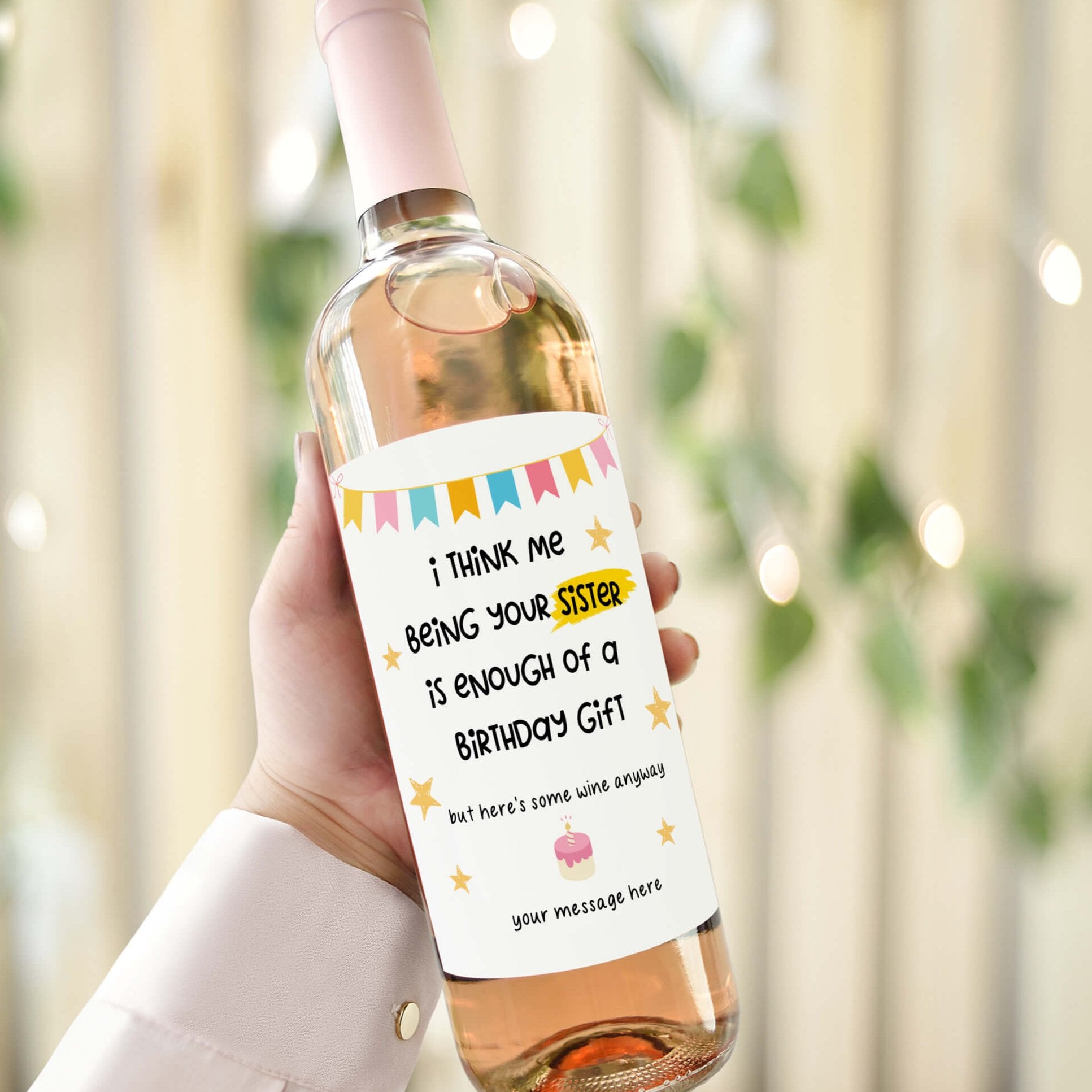 Wine bottle with a humorous birthday label reading 'I think me being your sister is enough of a birthday gift,' displayed with a festive background.