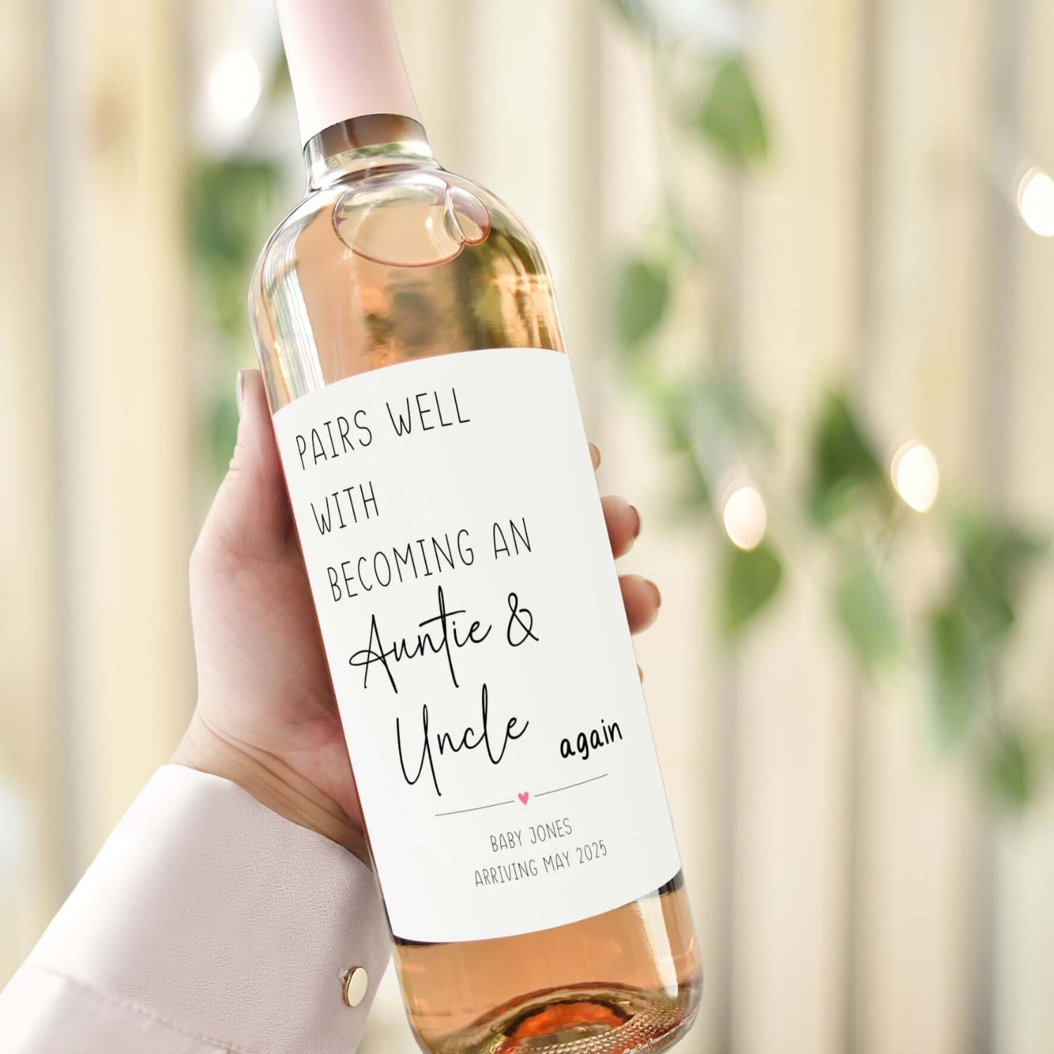 A wine bottle with a custom pregnancy reveal label reading "Pairs Well with Becoming an Auntie & Uncle Again," ideal for baby announcements.